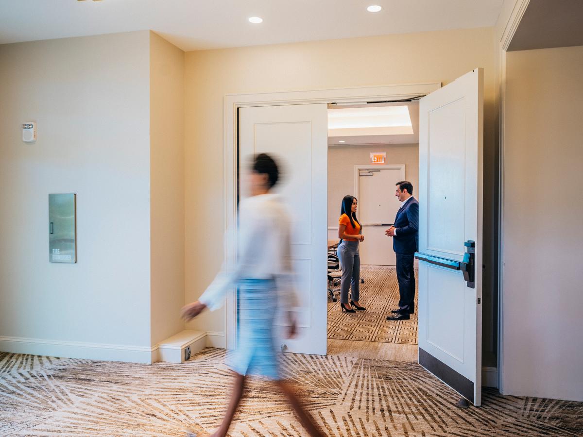Professionals speaking in an office hallway
